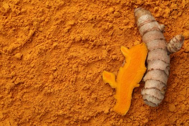Photo of Raw roots on aromatic turmeric powder, top view. Space for text