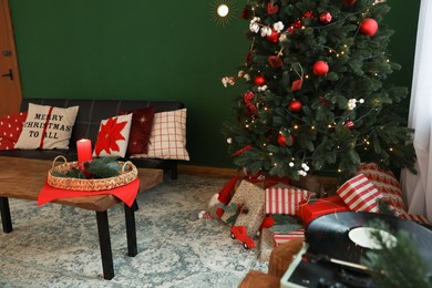 Photo of Cozy room with sofa, Christmas tree and festive decor. Interior design