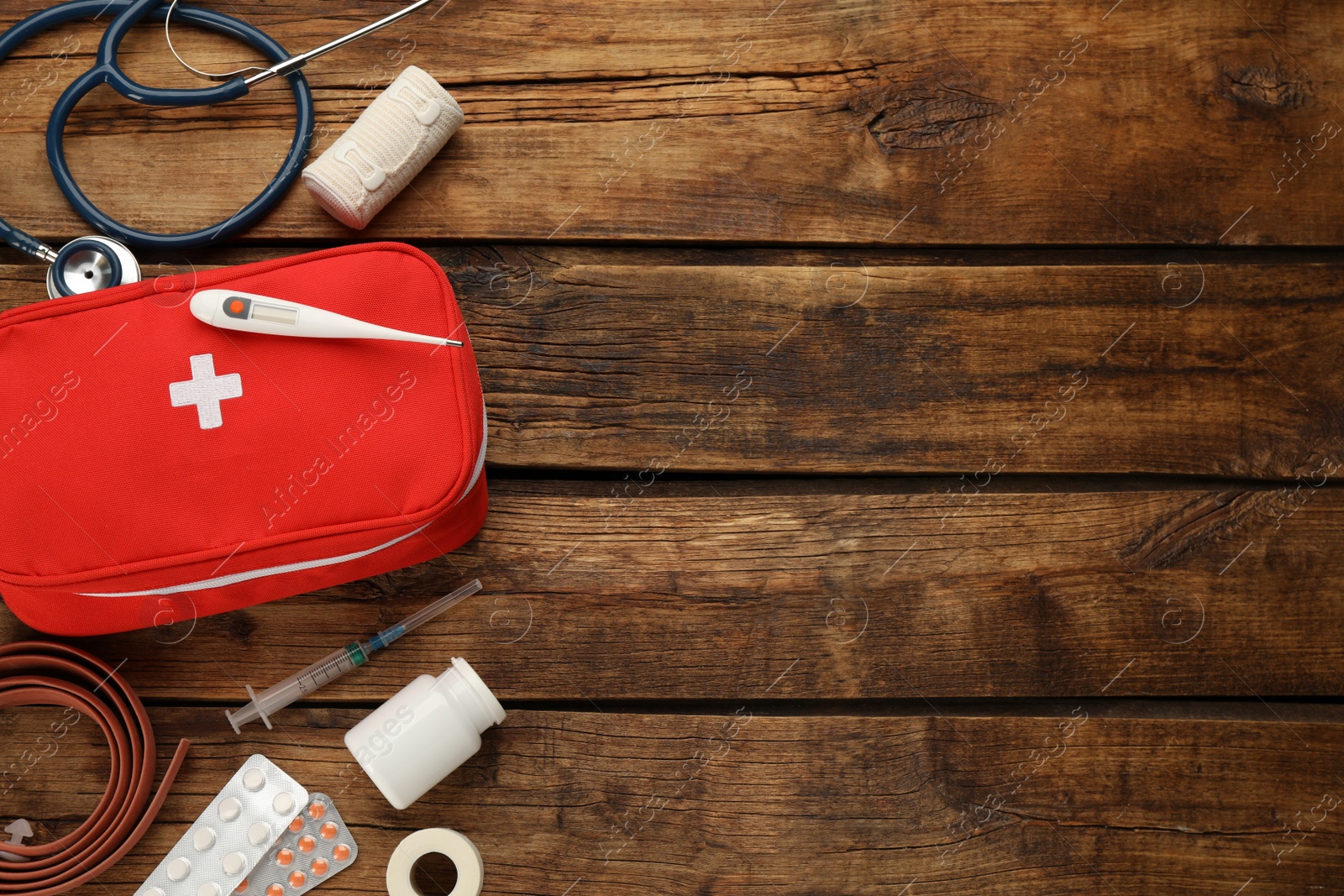 Photo of First aid kit on wooden table, flat lay. Space for text