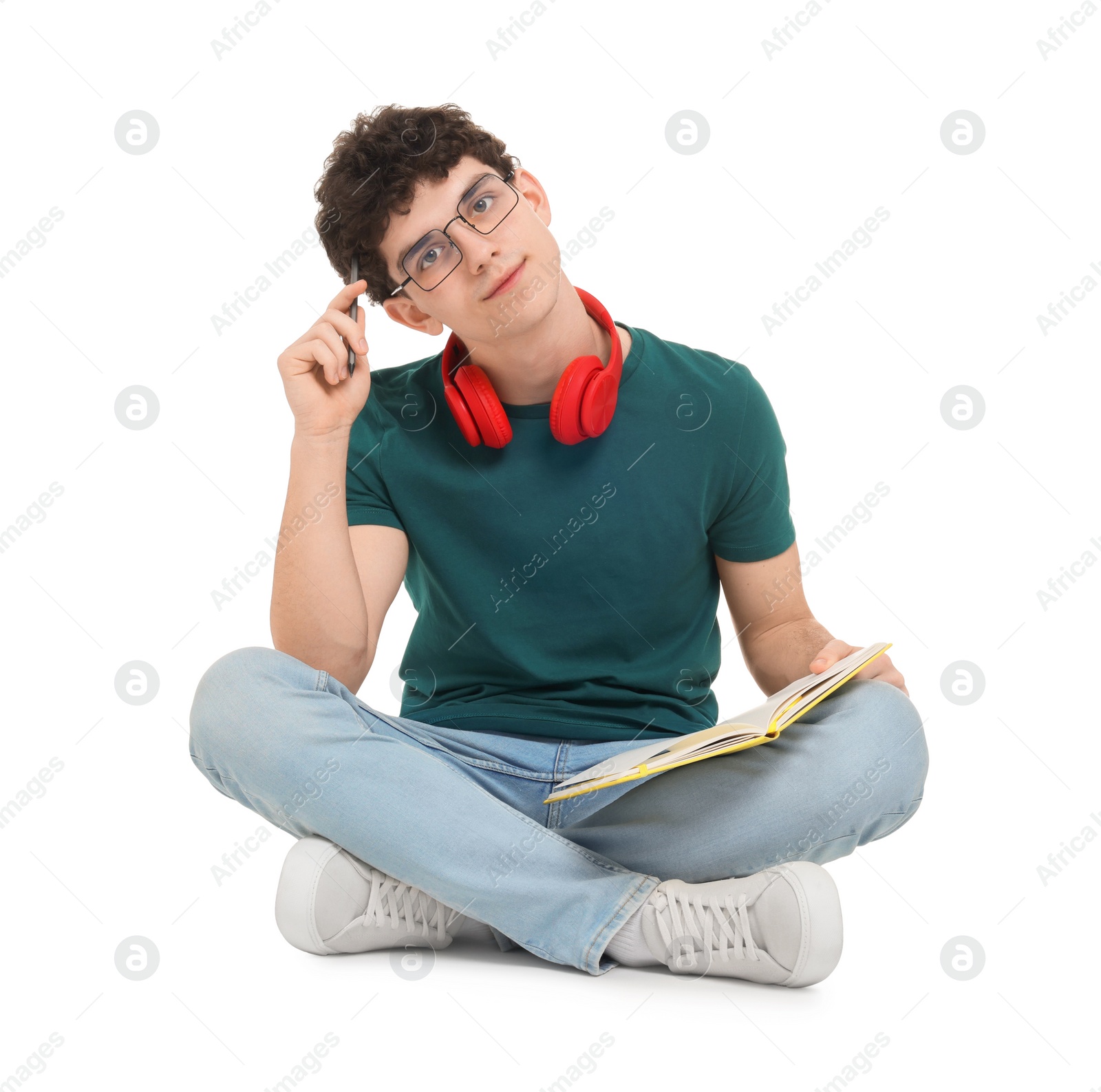 Photo of Portrait of student with notebook and headphones sitting on white background