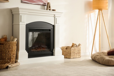 Bright living room interior with artificial fireplace and baskets of firewood