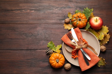 Festive table setting on wooden background, flat lay with space for text. Thanksgiving Day celebration