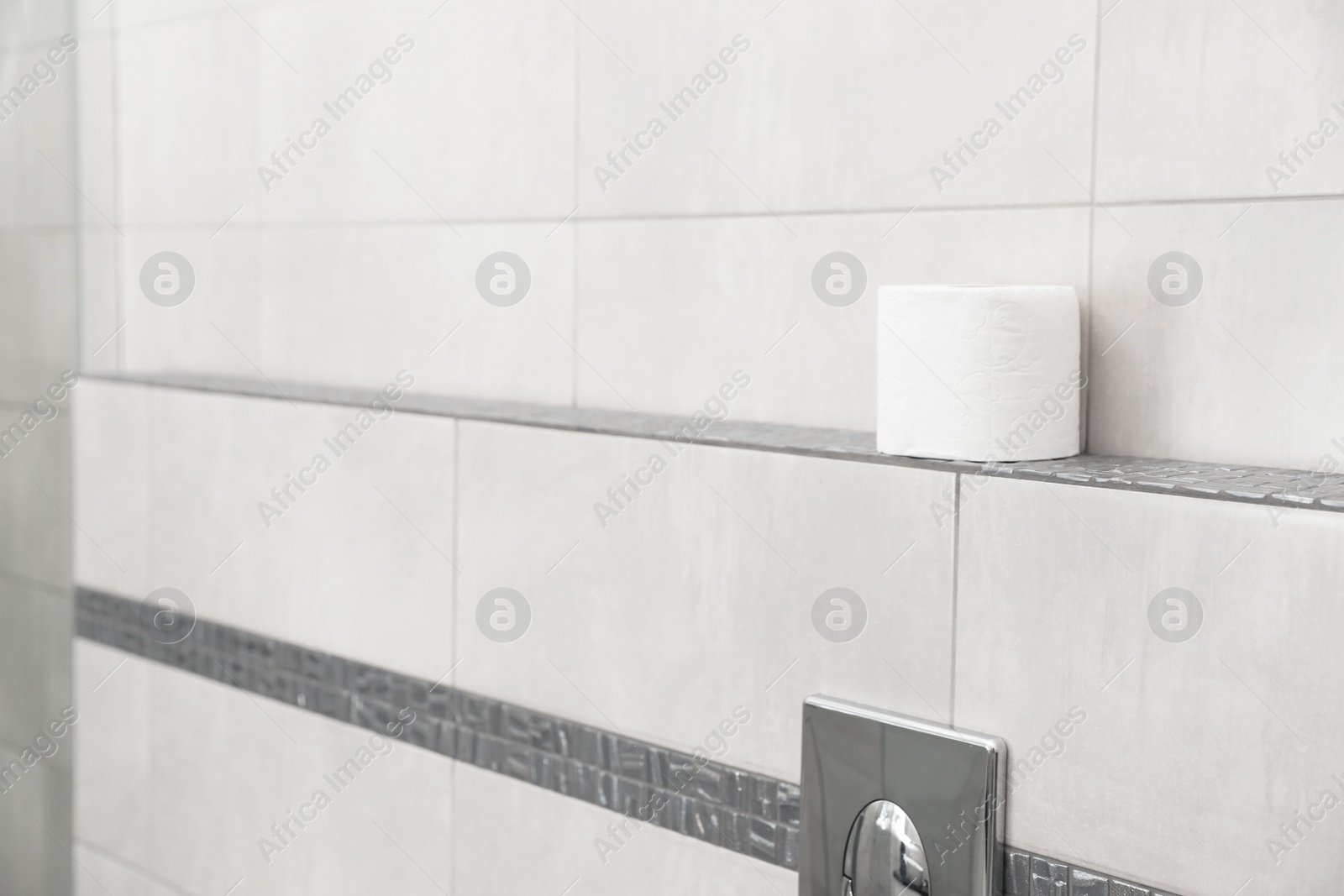 Photo of Toilet paper roll on shelf in bathroom. Space for text
