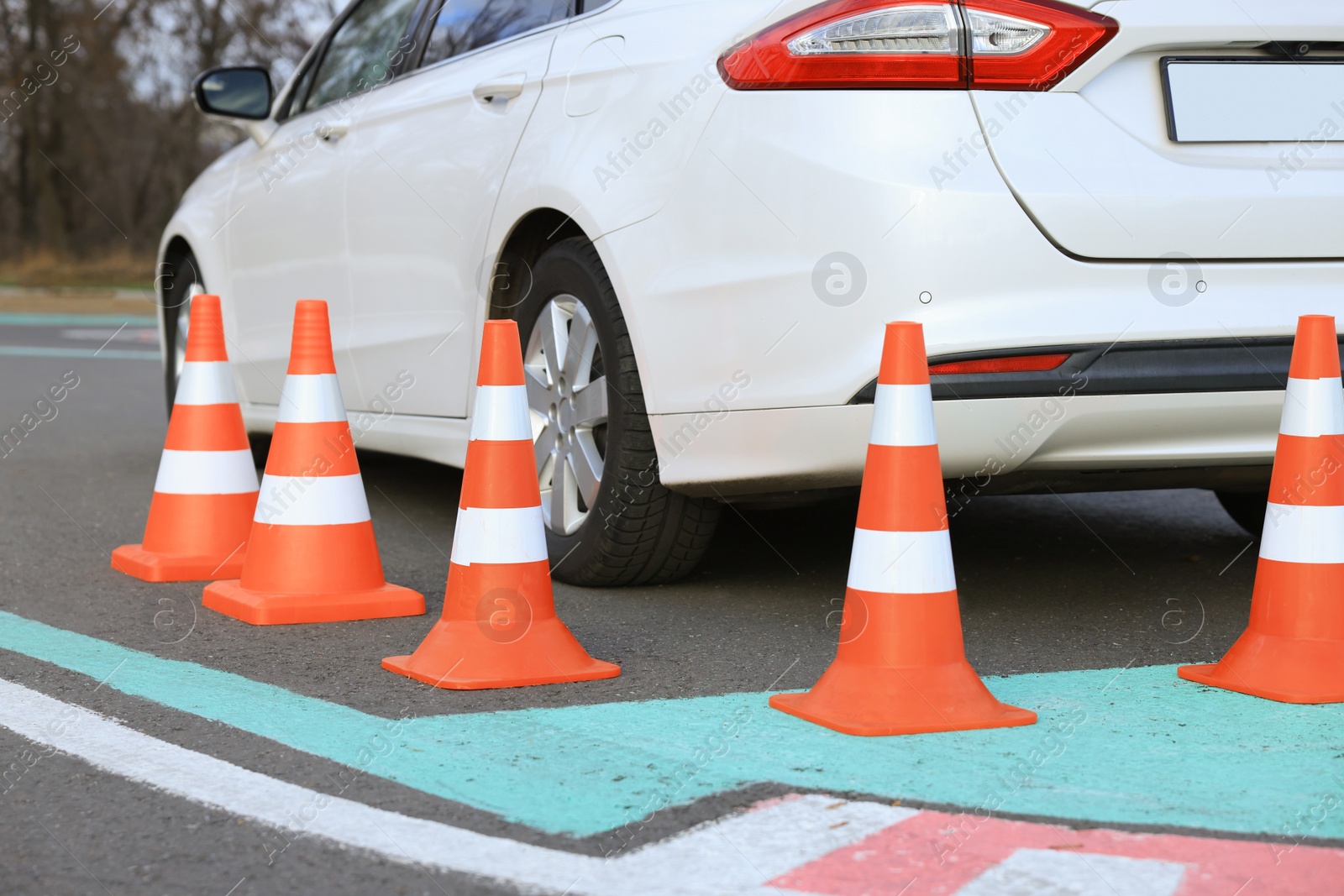 Photo of Modern car on driving school test track with traffic cones