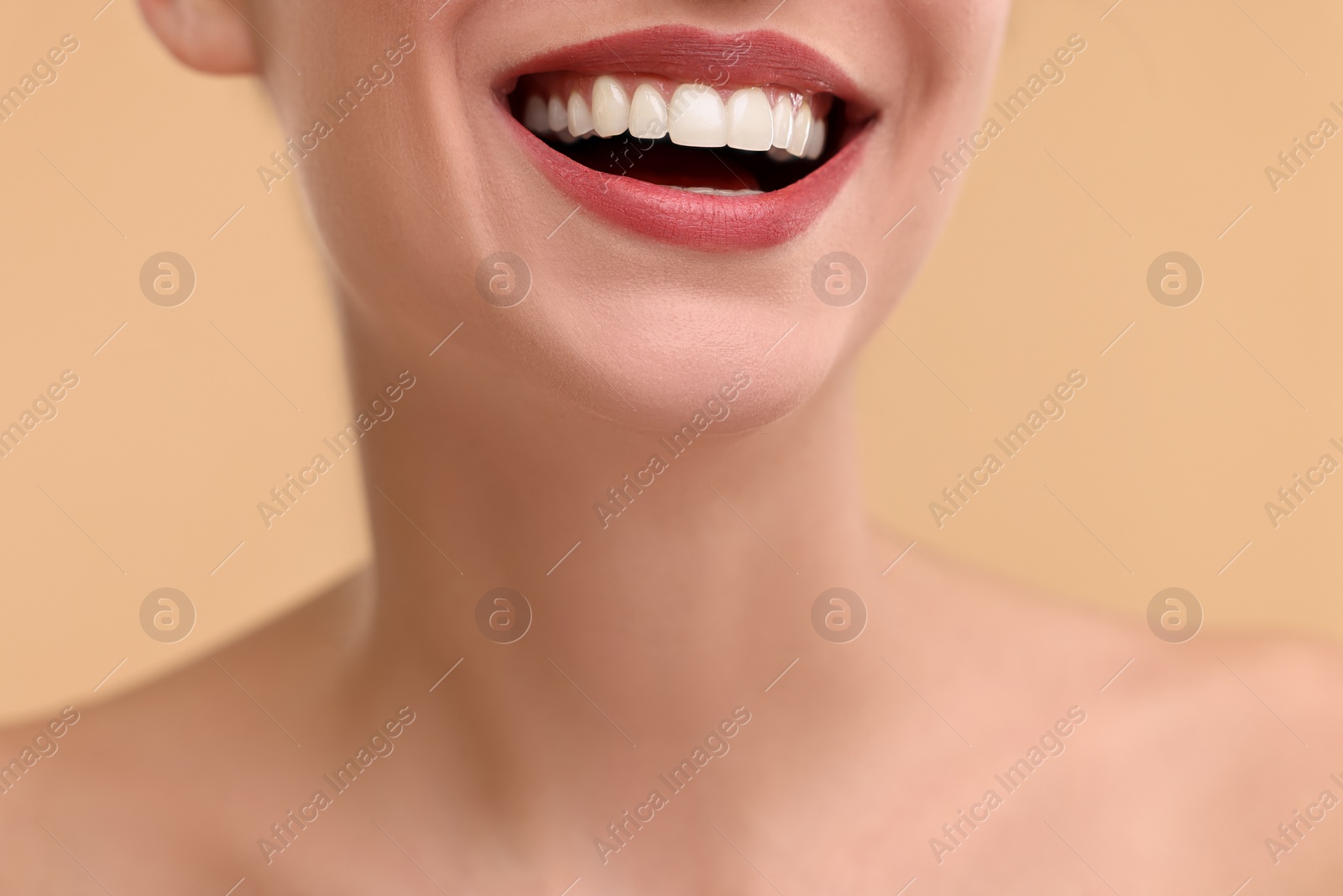 Photo of Woman with beautiful lips smiling on beige background, closeup