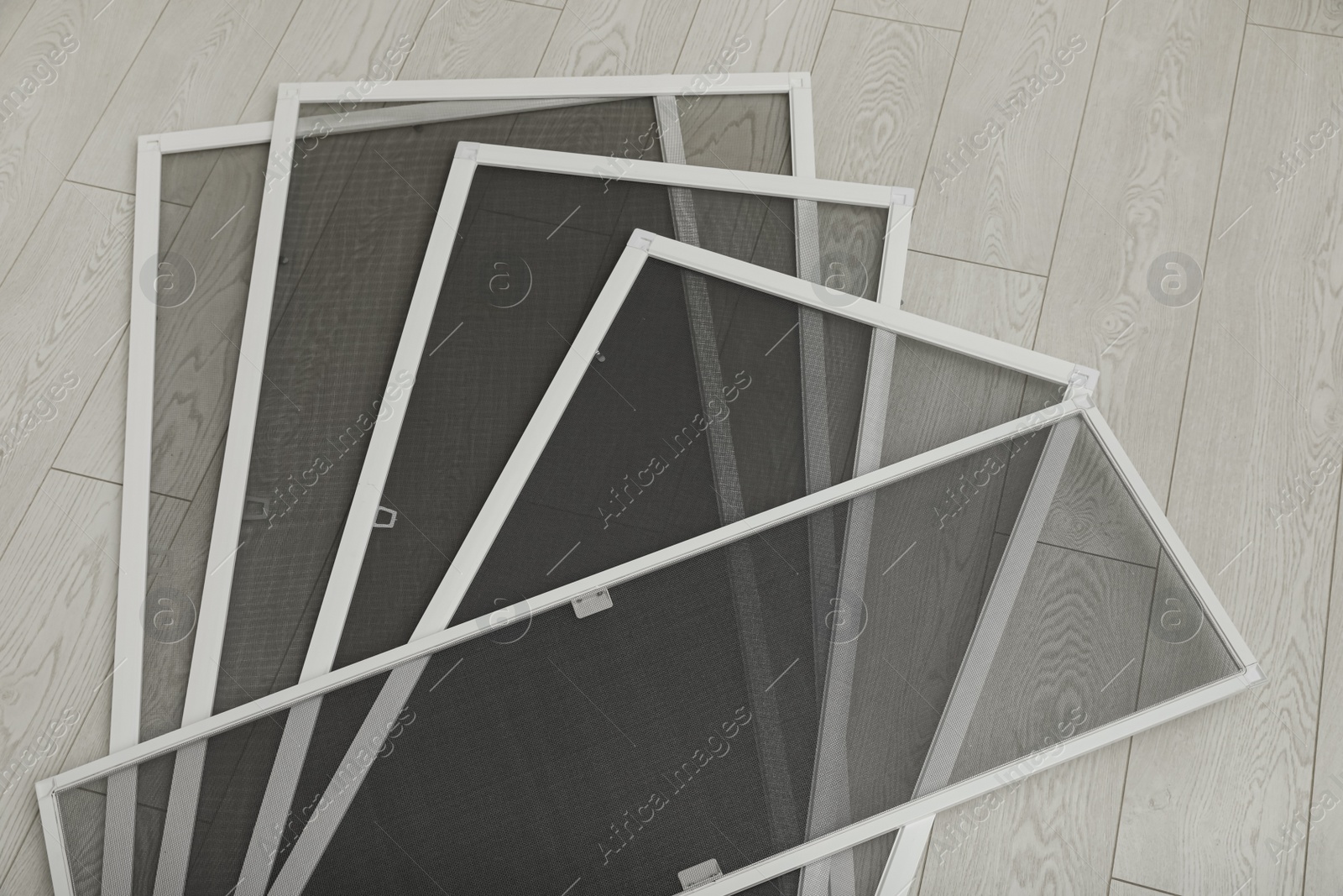 Photo of Set of window screens on wooden floor, flat lay