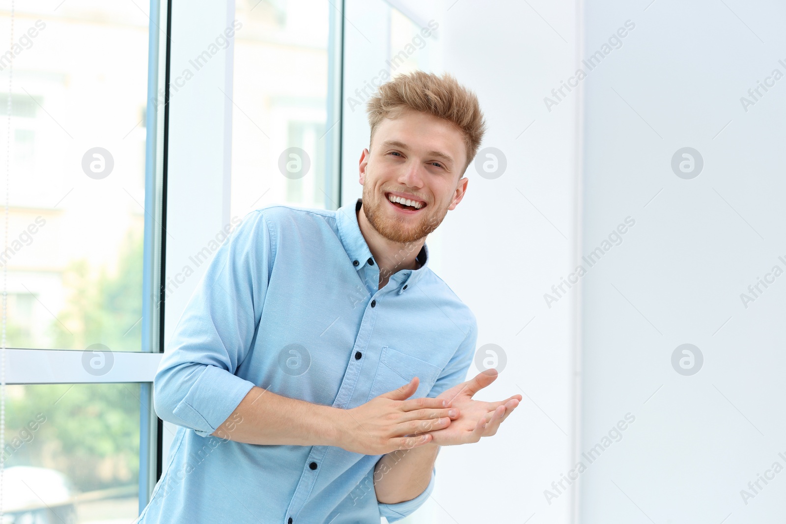 Photo of Portrait of handsome young man near window