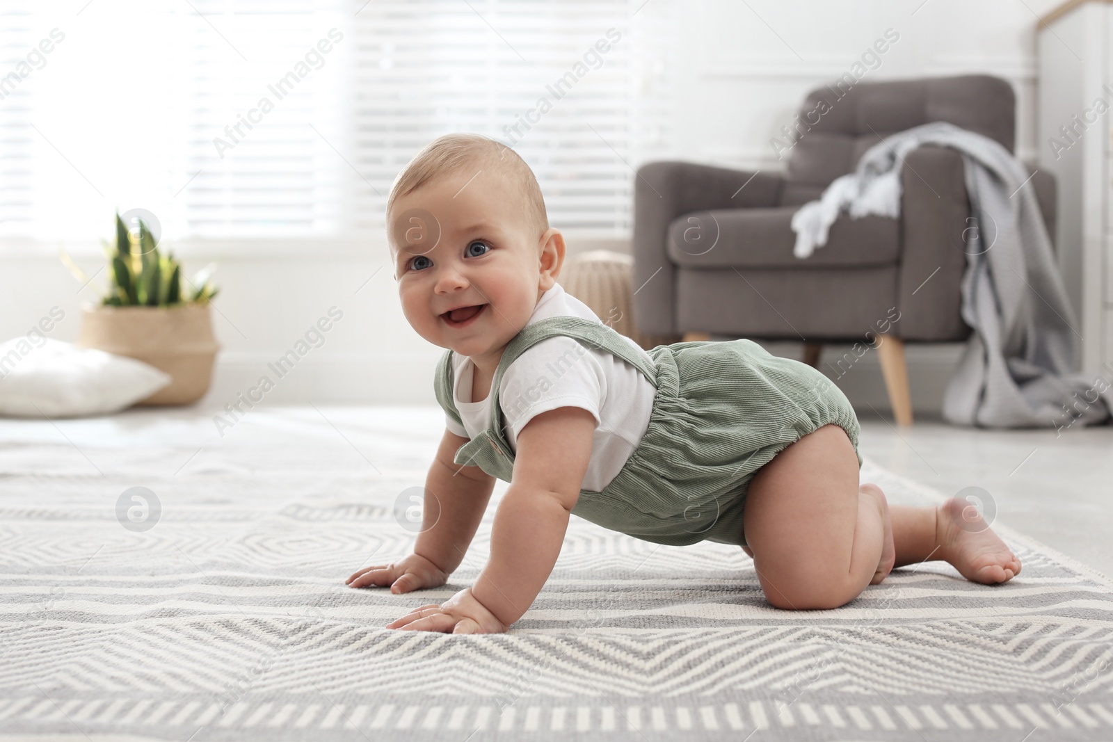 Photo of Cute baby crawling on floor at home