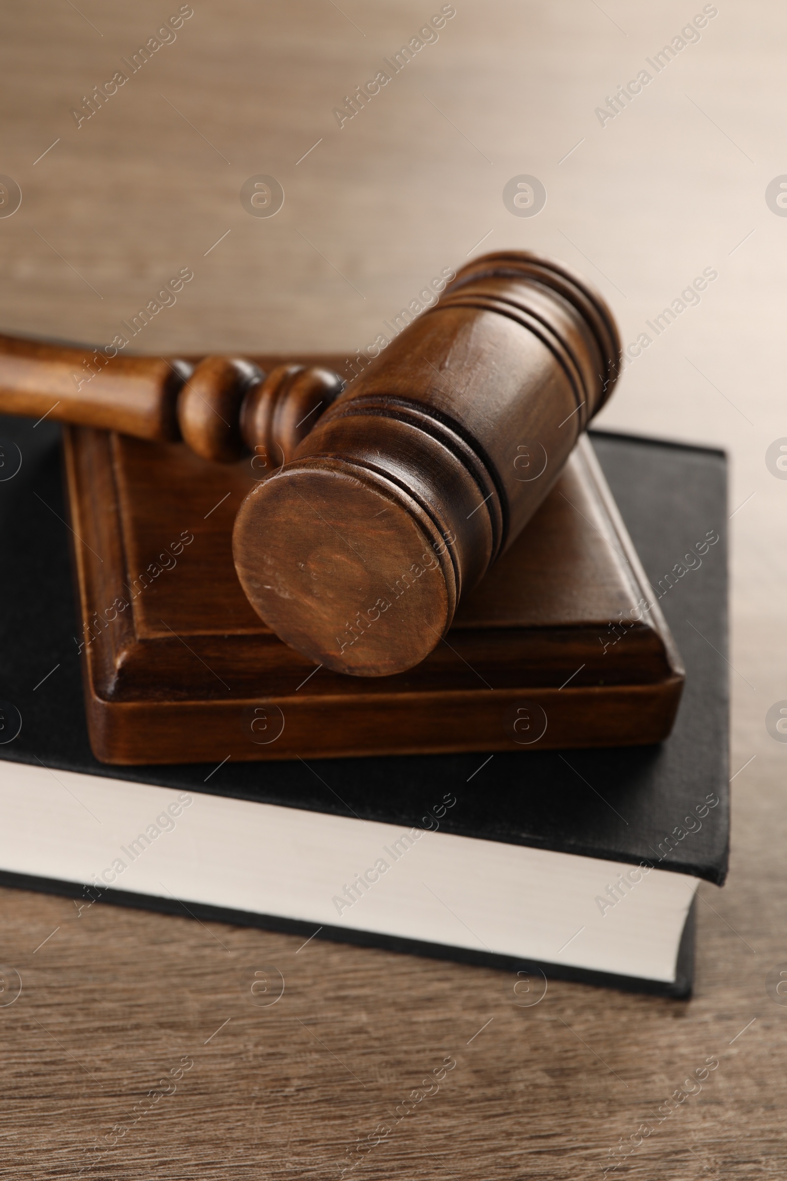 Photo of Law concept. Mallet and book on wooden table, closeup