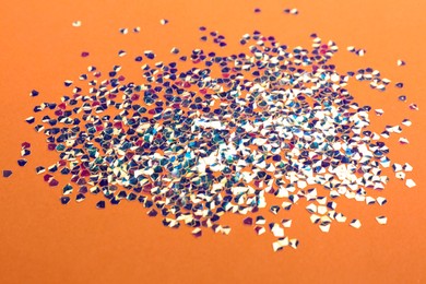 Photo of Shiny bright glitter scattered on coral background