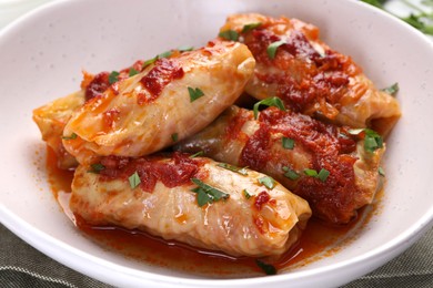 Delicious stuffed cabbage rolls cooked with homemade tomato sauce on table, closeup