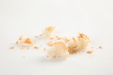 Photo of Scattered bread crumbs on white background, closeup