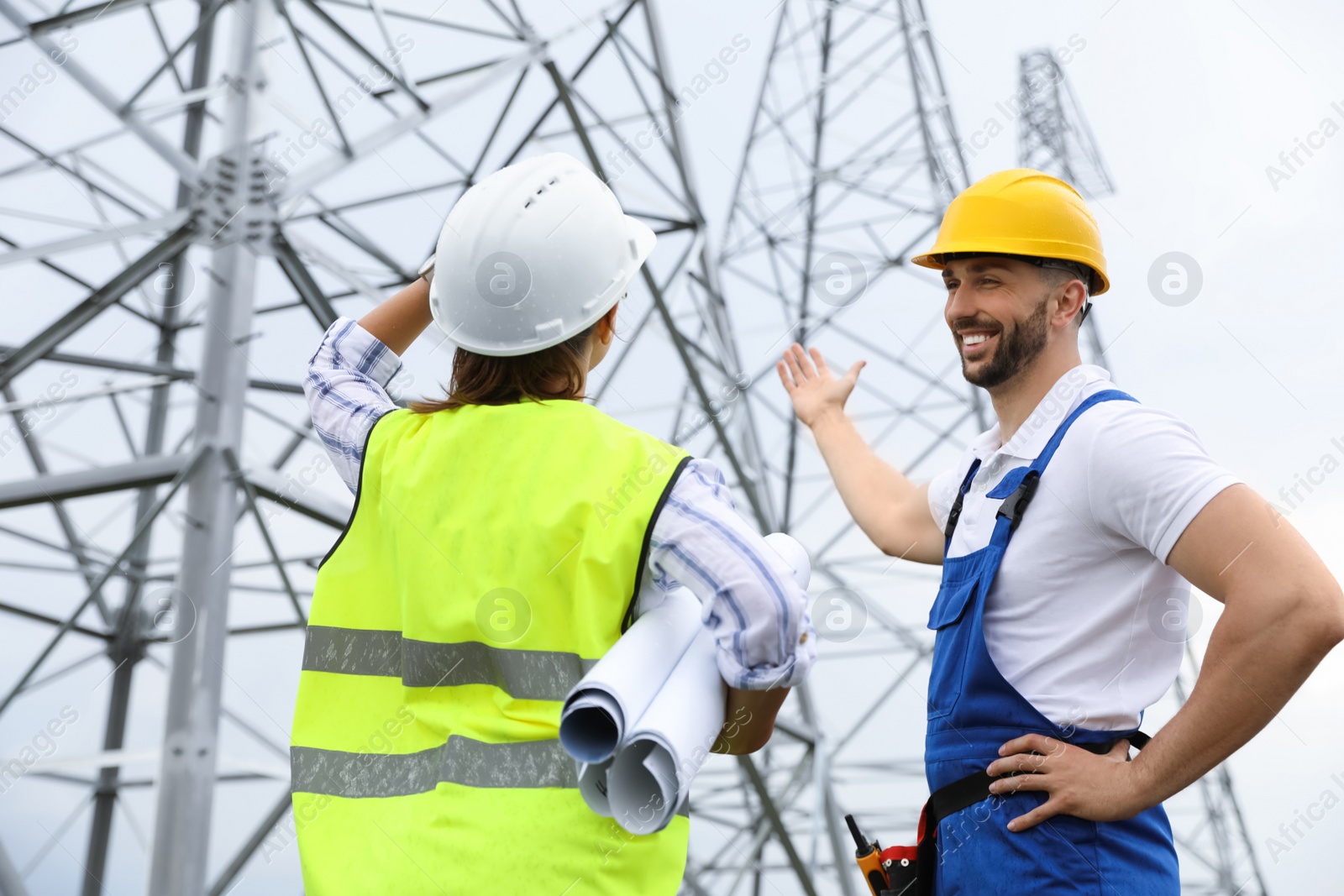 Photo of Professional engineers working on installation of electrical substation outdoors