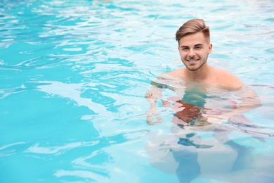 Photo of Young man in pool on sunny day