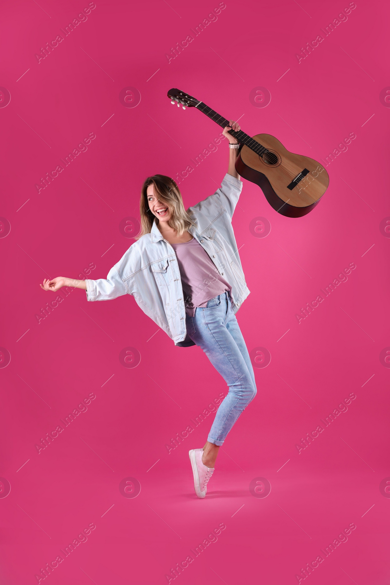 Photo of Young woman with acoustic guitar on color background