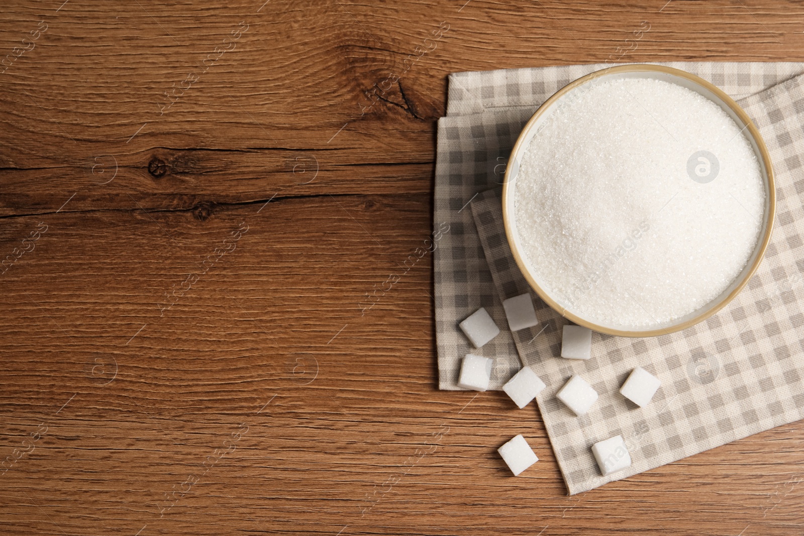 Photo of Granulated and refined sugar on wooden table, flat lay. Space for text