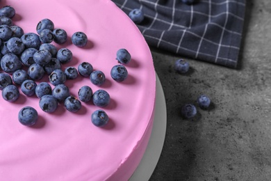 Photo of Tasty cheesecake with blueberries on grey table, closeup. Space for text