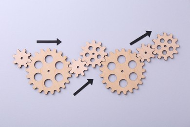 Business process organization and optimization. Scheme with wooden figures and arrows on lilac background, top view