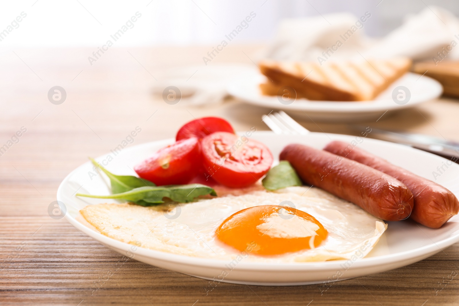 Photo of Tasty breakfast with fried egg on wooden table, closeup