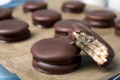 Photo of Tasty choco pies on parchment paper, closeup view