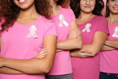 Photo of Group of women with silk ribbons, closeup. Breast cancer awareness concept