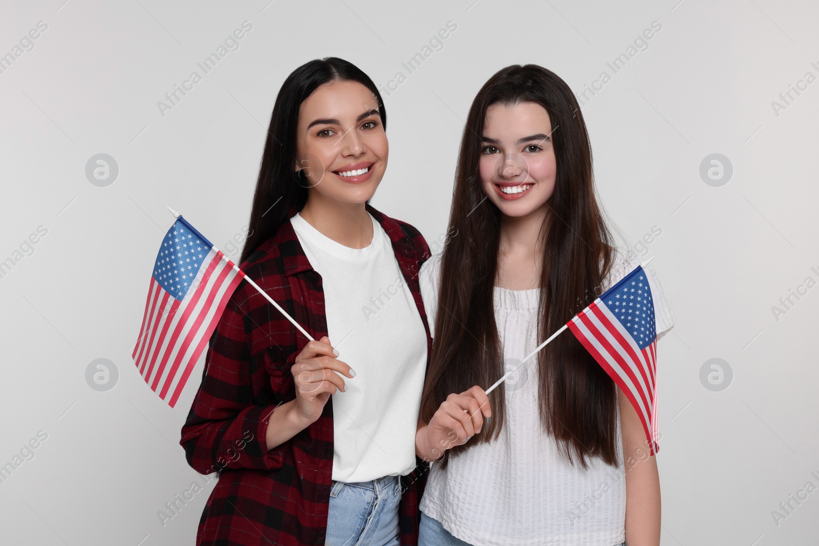 Photo of 4th of July - Independence Day of USA. Happy woman and her daughter with American flags on white background