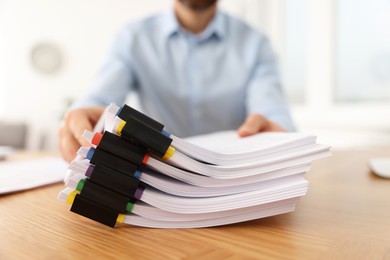 Photo of Businessman with documents at wooden table in office, closeup
