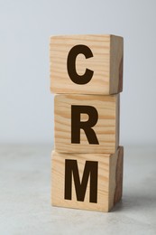 Abbreviation CRM of wooden cubes on light table, closeup. Customer Relationship Management