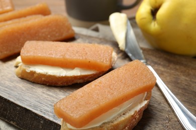 Photo of Quince paste sandwiches and fresh fruit on table, closeup