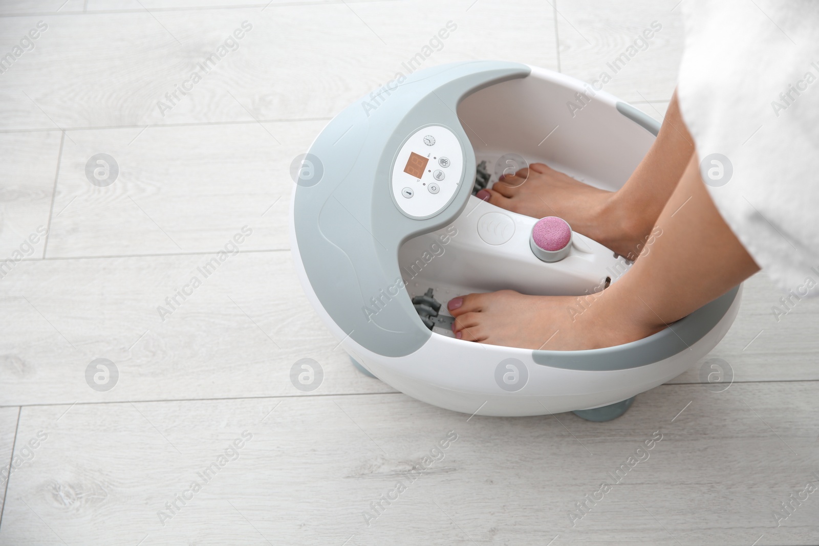 Photo of Woman with beautiful legs using foot bath at home, closeup with space for text. Spa treatment