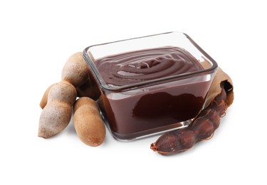 Photo of Bowl of tasty tamarind sauce and fresh pods isolated on white