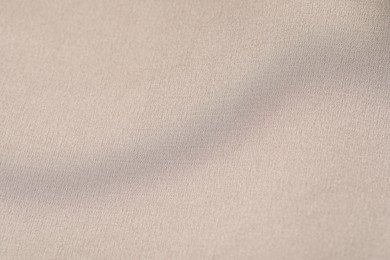 Photo of Texture of beige fabric as background, top view