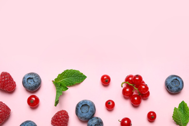 Photo of Mix of fresh berries on pink background, flat lay. Space for text