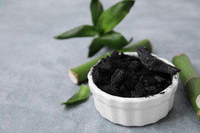 Photo of Bamboo charcoal and green stems on light gray background, closeup