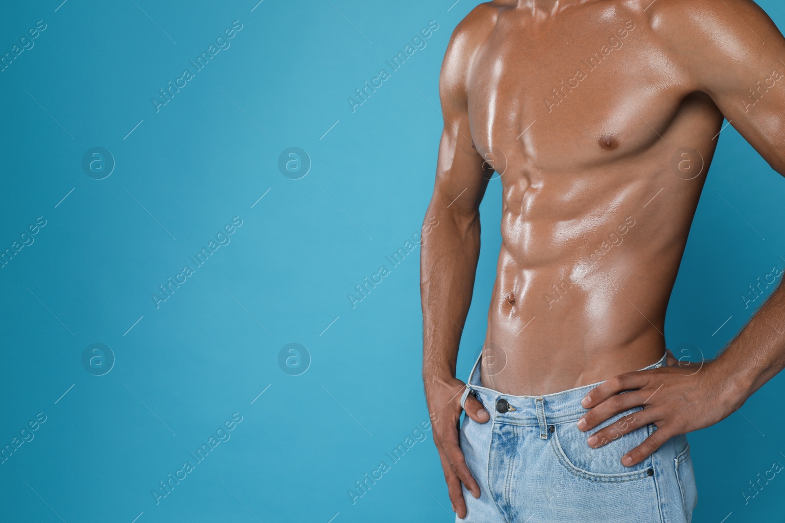 Photo of Shirtless man with slim body on light blue background, closeup. Space for text