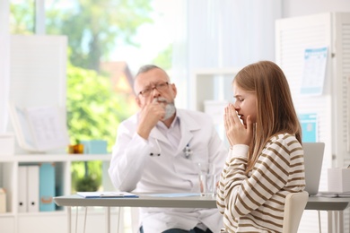 Photo of Coughing teenage girl visiting doctor at clinic