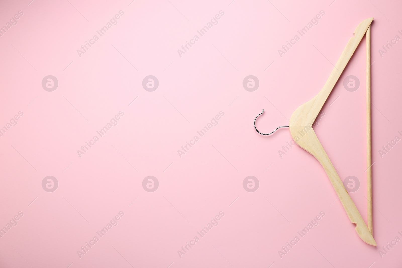 Photo of Wooden hanger on pink background, top view