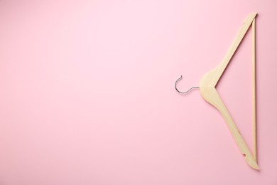 Photo of Wooden hanger on pink background, top view