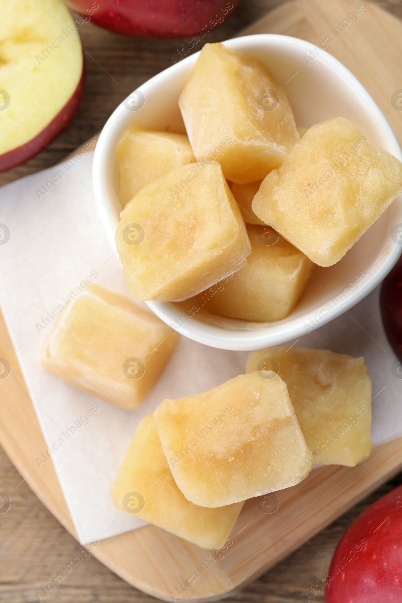 Photo of Frozen apple puree cubes and ingredient on wooden table, flat lay