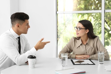 Office employees talking at table during meeting