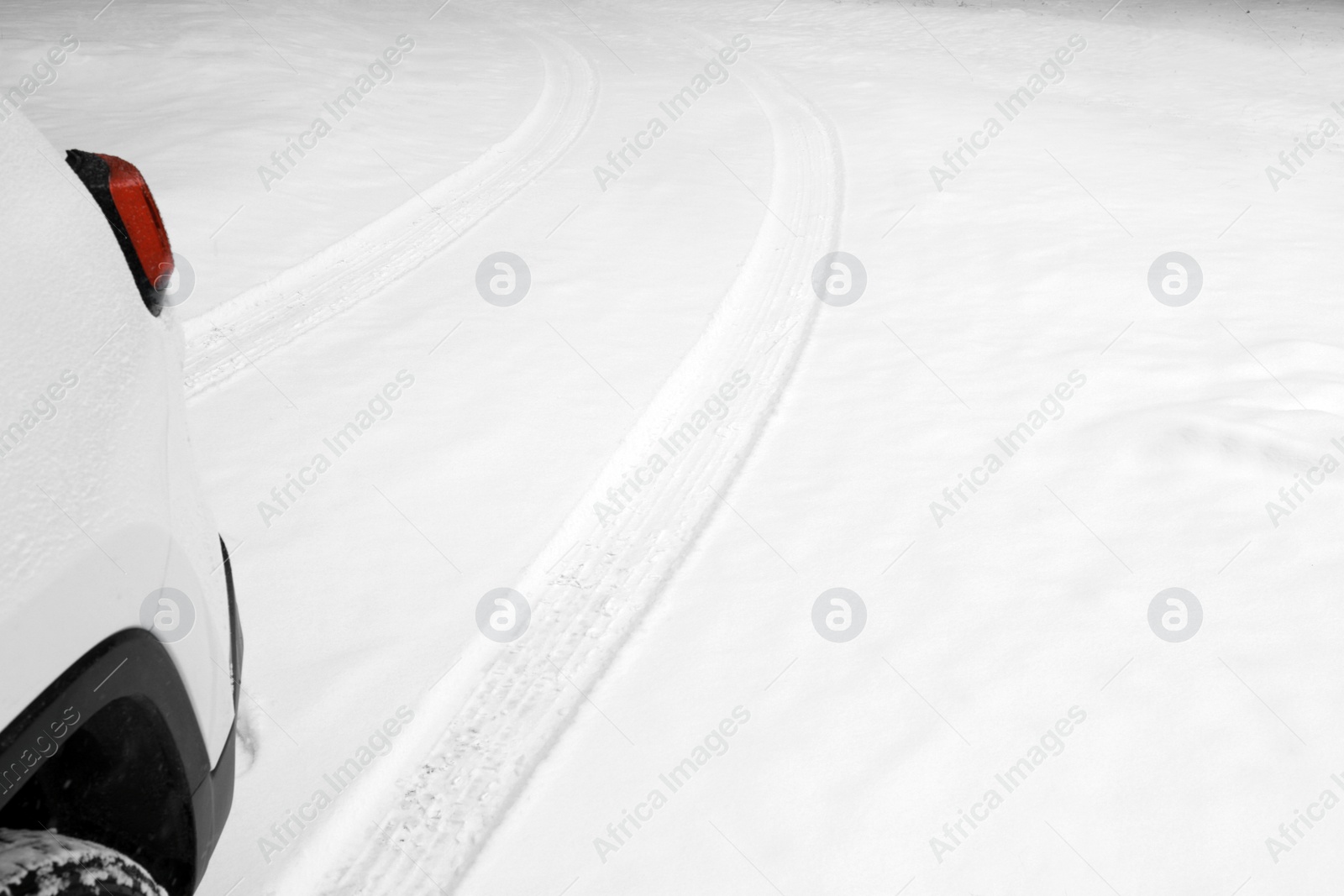 Photo of Modern car leaving tire tracks on snowy road, closeup view