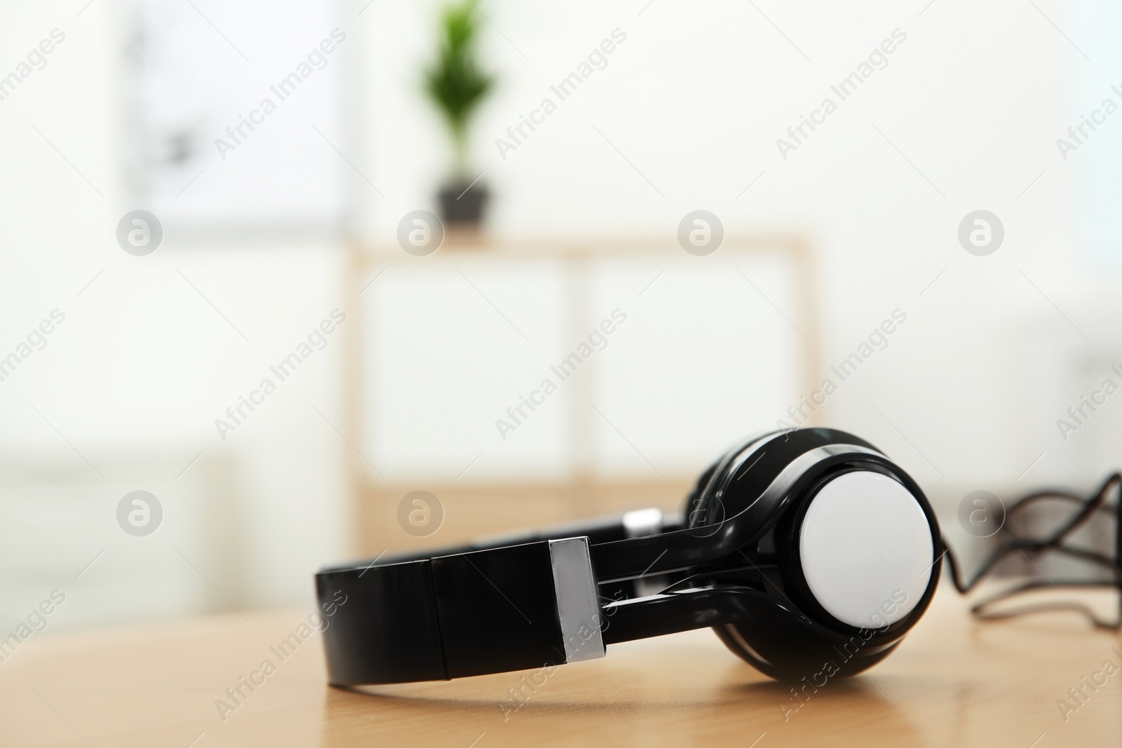 Photo of Stylish headphones on table indoors. Space for text