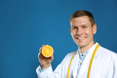 Nutritionist with orange on blue background. Space for text