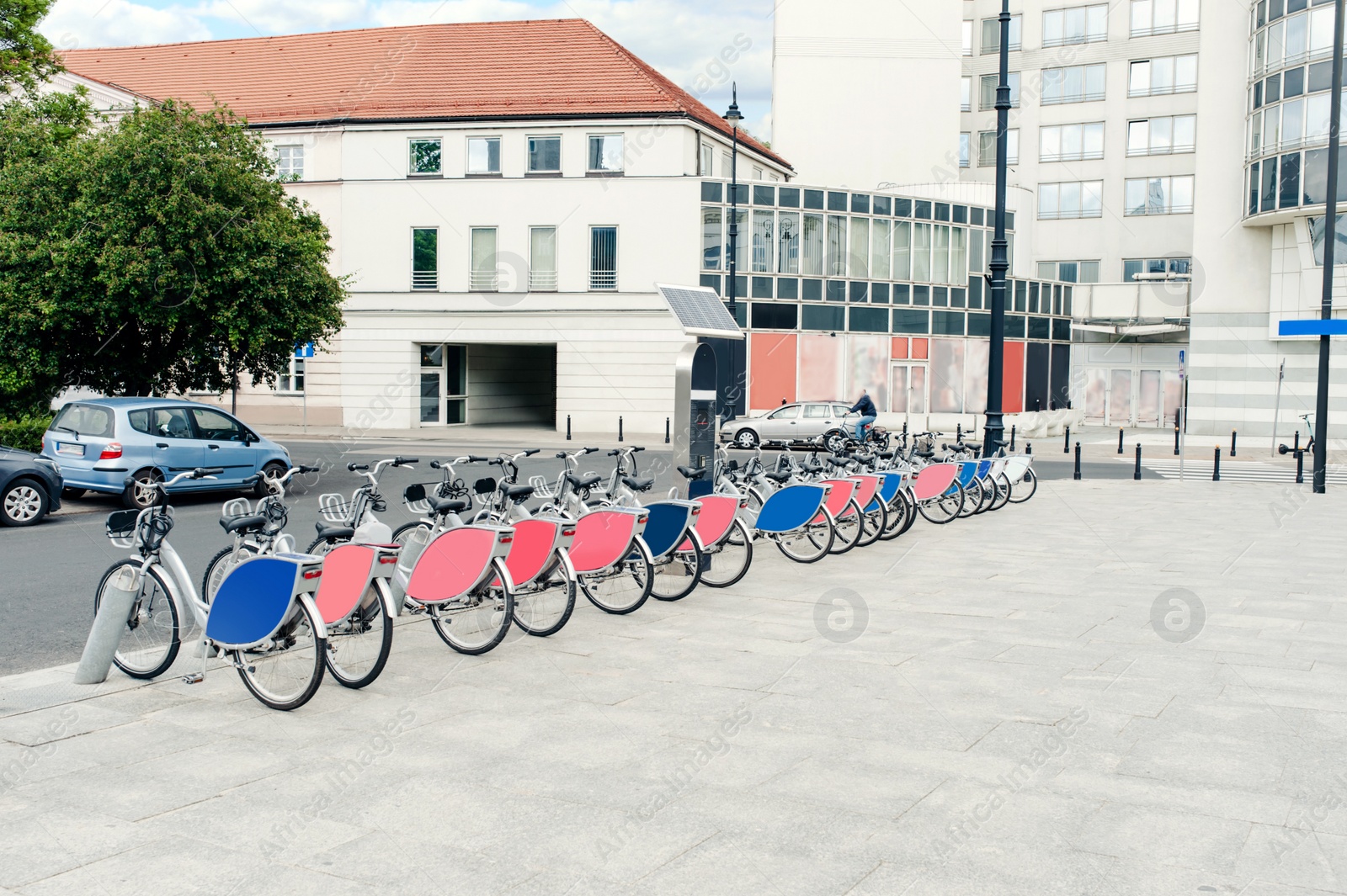 Photo of Many bicycles and station on city street. Bike rental fleet