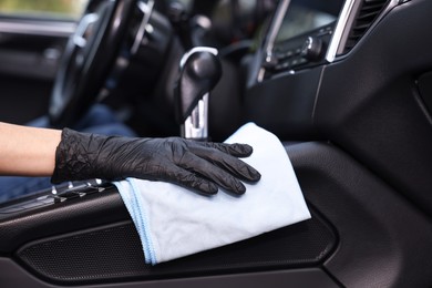 Woman wiping her modern car with rag, closeup