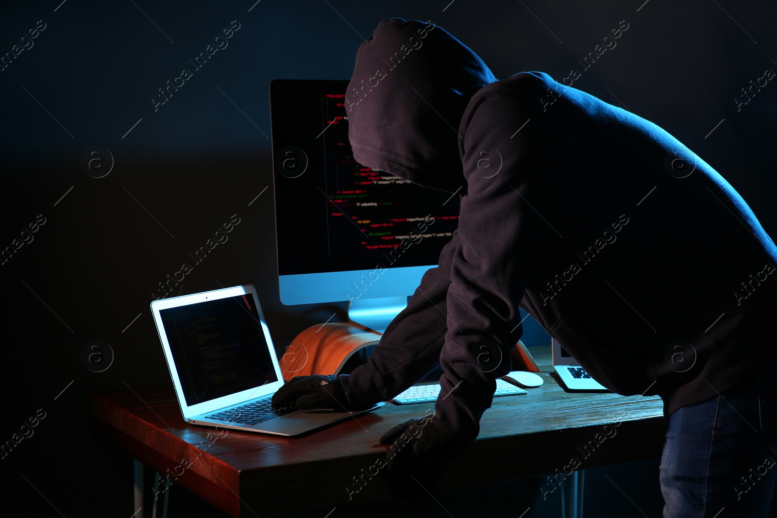 Photo of Hacker with computers in dark room. Cyber crime