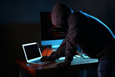 Hacker with computers in dark room. Cyber crime