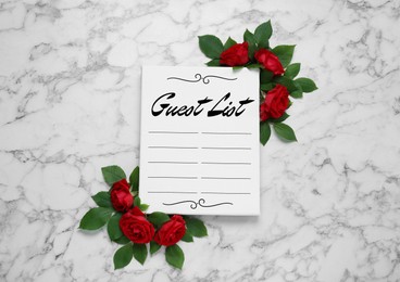 Image of Beautiful flowers and guest list on white marble background, flat lay