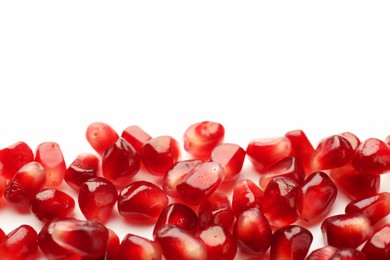 Photo of Many ripe juicy pomegranate grains on white background, flat lay. Space for text