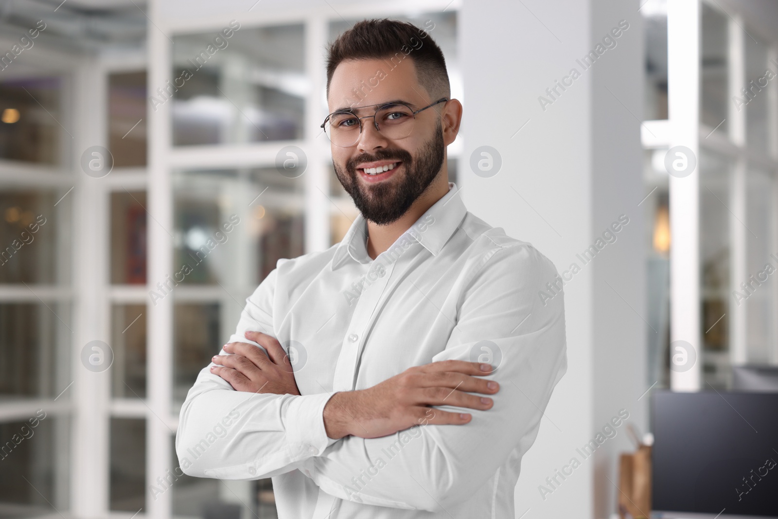 Photo of Portrait of smiling man with crossed arms in office. Lawyer, businessman, accountant or manager